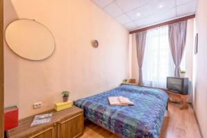 a bedroom with a bed and a mirror and a tv at WonderHostel on Nevsky 23 in Saint Petersburg