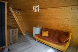 a couch in a room with a wooden wall at Tbilisi Sea Breeze in Tbilisi City