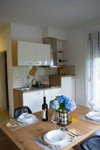 a kitchen with a wooden table with plates and wine glasses at Kraljeva hiža - Apartmani i sobe Kralj in Sveti Martin na Muri