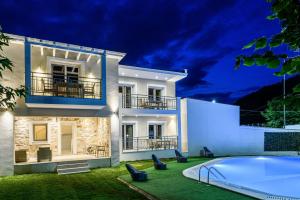 a villa with a swimming pool at night at Sunny Memories Apartments in Limenas