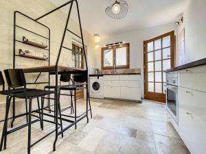 uma cozinha com uma mesa e cadeiras em Appartement cosy avec cuisine équipée et terrasse ensoleillée em Talence