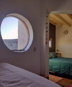 a bedroom with a bed and a round window at Trotamundos CASA in Puerto Pirámides