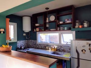 a kitchen with blue walls and a white refrigerator at Trotamundos CASA in Puerto Pirámides