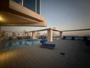 a large building with a pool and a blue chair at Grand Bay Tower in Panama City