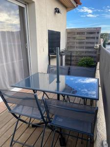 - Balcón con mesa de cristal y 2 sillas en Charmant appartement T3 la Ciotat en La Ciotat