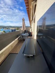 a balcony with a table and an umbrella on a roof at Charmant appartement T3 la Ciotat in La Ciotat