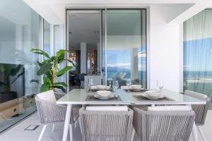 ein Esszimmer mit einem weißen Tisch und Stühlen in der Unterkunft Crystal I Luxury Apartments by EnjoyaHome in Santiago del Teide