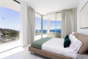 een slaapkamer met een bed en grote glazen ramen bij Crystal I Luxury Apartments by EnjoyaHome in Santiago del Teide