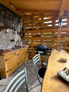 cocina con armarios de madera, mesa y fogones en Къща за гости Ози, en Ovchartsi