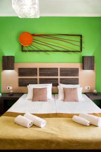 ラガナスにあるAcapulco Marinos Apartments- Adults Onlyの緑の壁のベッドルーム1室(ベッド2台付)