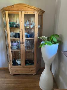 a wooden cabinet with a white vase and a plant at Augļu ielas viesu māja in Jūrmala