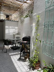 een patio met een tafel en stoelen en een grill bij Hermosa y céntrica casa Altamar in Santa Marta