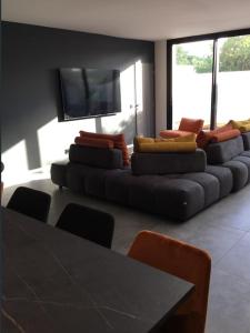 sala de estar con sofá y TV de pantalla plana en Villa avec piscine bord de mer CARNON en Carnon-Plage