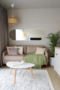 ein Wohnzimmer mit einem Sofa und einem Tisch in der Unterkunft APARTAMENTY NADJEZIORNE z tarasem na dachu in Lyck