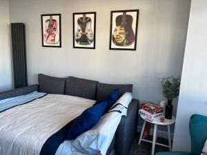a bed in a room with four pictures on the wall at The Wedge, Seaside Beach House - Sleeps 6 in Southend-on-Sea