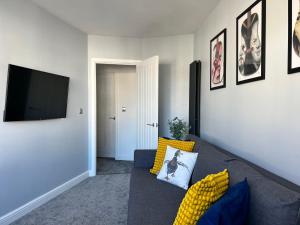 a living room with a couch and a flat screen tv at Luxury Retreat Beach House - Sleeps 6 in Southend-on-Sea
