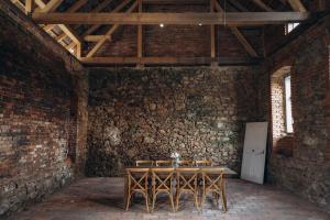 um quarto com uma mesa e cadeiras numa parede de tijolos em Usedlost Jindřichovice em Jindřichovice