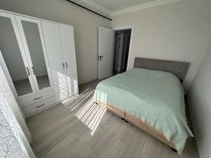 a white bedroom with a bed and a closet at Müstakil Bahçeli Yazlık in Karasu