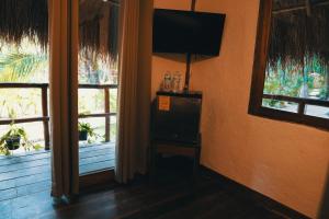 een kamer met 2 ramen en een flatscreen-tv bij Bluebayou Bacalar in Bacalar