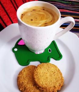 a cup of coffee and a cookie on a plate at Zein Pyramids View - Guest House in Cairo