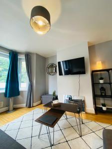 sala de estar con mesa y TV en Medway Getaway - 3 Bed Home with Luxury Bathroom en Chatham
