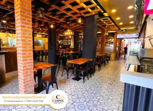 une salle à manger avec des tables et des chaises en bois dans l'établissement Hostal Campos Rancagua, à Rancagua