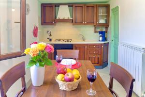 un tavolo da cucina con un cesto di frutta e bicchieri da vino di Casa Mara - Diano Serreta a Diano Marina