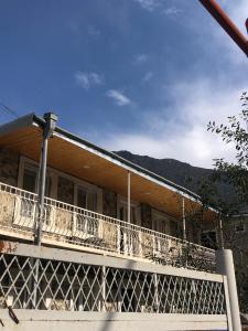 ein Haus mit einer großen Terrasse mit Bergen im Hintergrund in der Unterkunft House 54 in Kazbegi