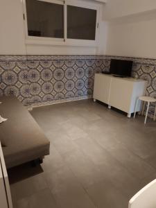 a room with a couch and a table and a wall at Your Home near the beach - Sesimbra in Sesimbra