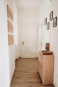 a hallway with a wooden dresser and a white door at Usedlost Jindřichovice 