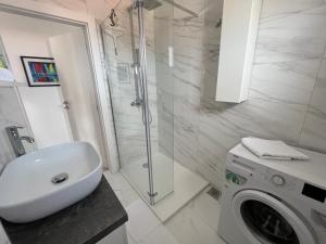 a bathroom with a sink and a washing machine at La Fee studio apartment in Hvar