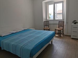 1 Schlafzimmer mit einem Bett, 2 Stühlen und einem Fenster in der Unterkunft Casa Crevatini in Koper