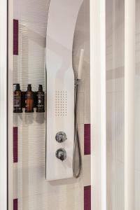 a shower in a bathroom with a white shower head at BNBHolder Apartamentos en Sol Deluxe 1 in Madrid