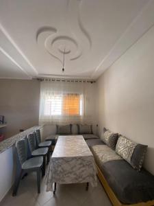 sala de estar con sofá, mesa y sillas en Appartement proche de la corniche en Alhucemas