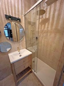 uma casa de banho com um chuveiro, um lavatório e um espelho. em LE PECHEUR DE CASSIS em Cassis