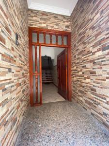 an empty room with a brick wall and a door at Appartement proche de la corniche in Al Hoceïma