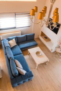 a living room with a blue couch and a table at ANESIS Luxury Apartment in Lefkada