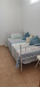 a bedroom with two beds and a chair at Apartamento zona Parque Comercial in Mojácar