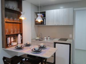 a kitchen with a table with cups and plates on it at SUNNY HALL in Porto De Galinhas