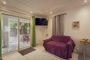a living room with a chair and a sliding glass door at Pierre's Place Grand-Case, a place to dream in Grand Case