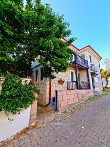 a brick house with a tree in front of it at Paradise İmroz Butik Otel in Gokceada Town