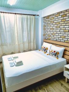 um quarto com uma cama com uma parede de tijolos em Paradise İmroz Butik Otel em Gokceada Town