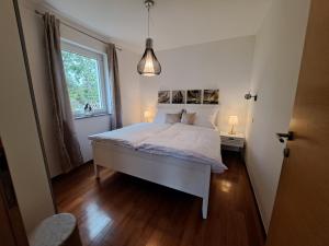 a bedroom with a white bed and a window at Apartments Villa Sotlar with pool in Umag
