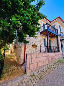 um edifício com uma varanda ao lado em Paradise İmroz Butik Otel em Gokceada Town