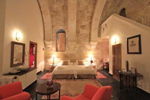 a hotel room with a bed and two chairs at Posada Real Castillo del Buen Amor in Villanueva de Cañedo