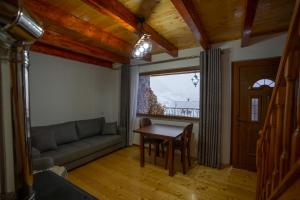 ein Wohnzimmer mit einem Sofa und einem Tisch in der Unterkunft Vila Alpini Lepushe in Lëpushë