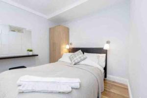 a white bedroom with a large bed with white sheets at Beautiful 3 bedrooms apartment in London