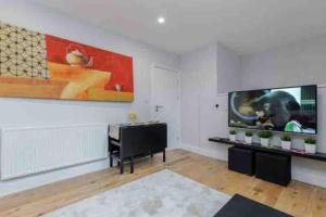 a living room with a flat screen tv and a piano at Beautiful 3 bedrooms apartment in London