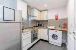 a kitchen with a washing machine and a washer at Beautiful 3 bedrooms apartment in London