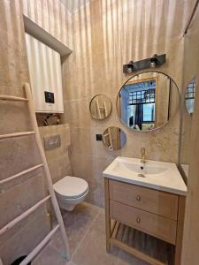 uma casa de banho com um lavatório, um WC e um espelho. em LE PECHEUR DE CASSIS em Cassis